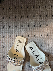 ALAIA FOLDED FLAT MULES WITH SPHERES ON WHITE CALFSKIN