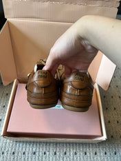 MIUMIU 26S GYMNASIUM SNEAKER IN COGNAC BROWN CALFSKIN WITH GOLD BUCKLED STRAP