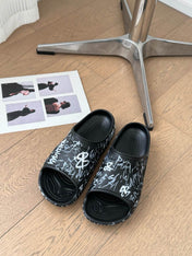 POOL GRAFFITI CROCS SLIDE SANDALS IN BLACK AND WHITE RUBBER