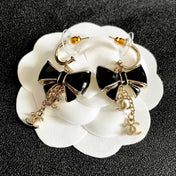 CHANEL 26S DOUBLE C LOGO BLACK ENAMEL BOW DANGLE EARRINGS WITH CHAIN CHARMS IN GOLD METAL 629178