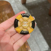 CHANEL 26S DOUBLE C LOGO PARIS ROUND ENAMEL BROOCH IN BLACK & AMBER WITH ROPE DETAIL GOLD METAL 629194