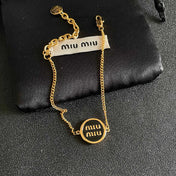 MIUMIU 26S LOGO ROUND BRACELET IN BLACK ENAMEL AND GOLD TONE METAL 631809
