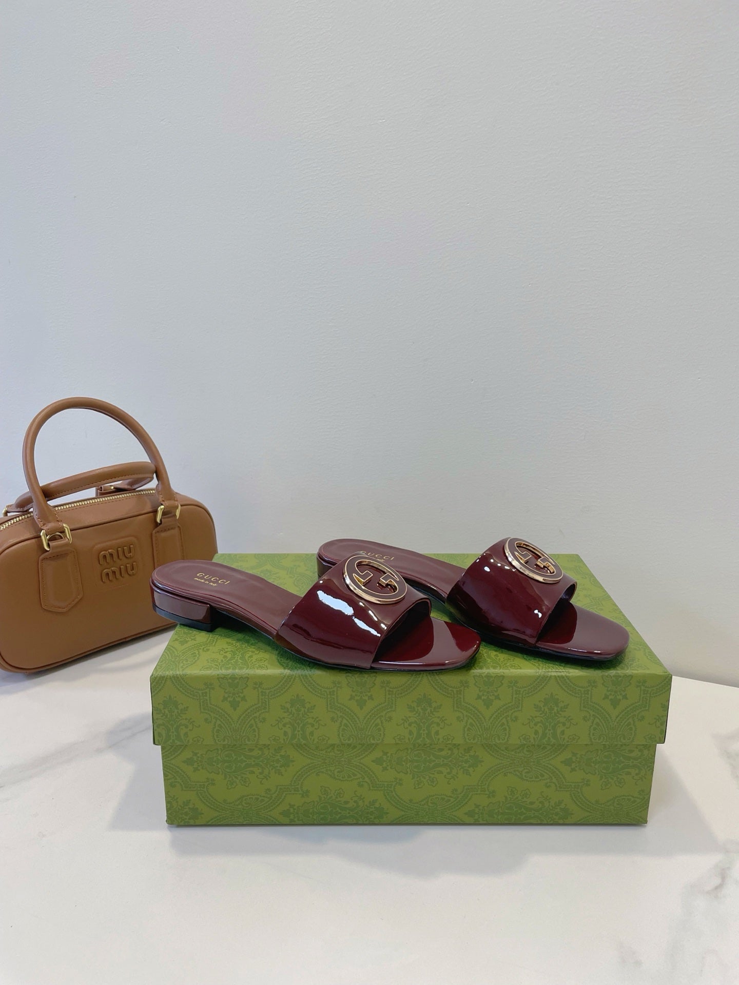 SLIDE SANDALS IN WINE RED GLOSSY SHEEPSKIN ENAMELLED ROUND INTERLOCKING G